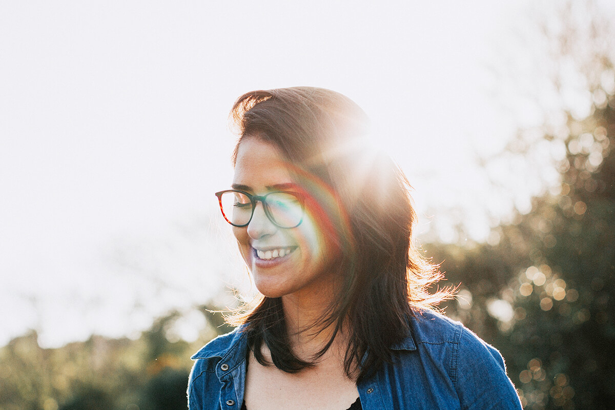 Lachende Frau mit Brille im Sonnenlicht
